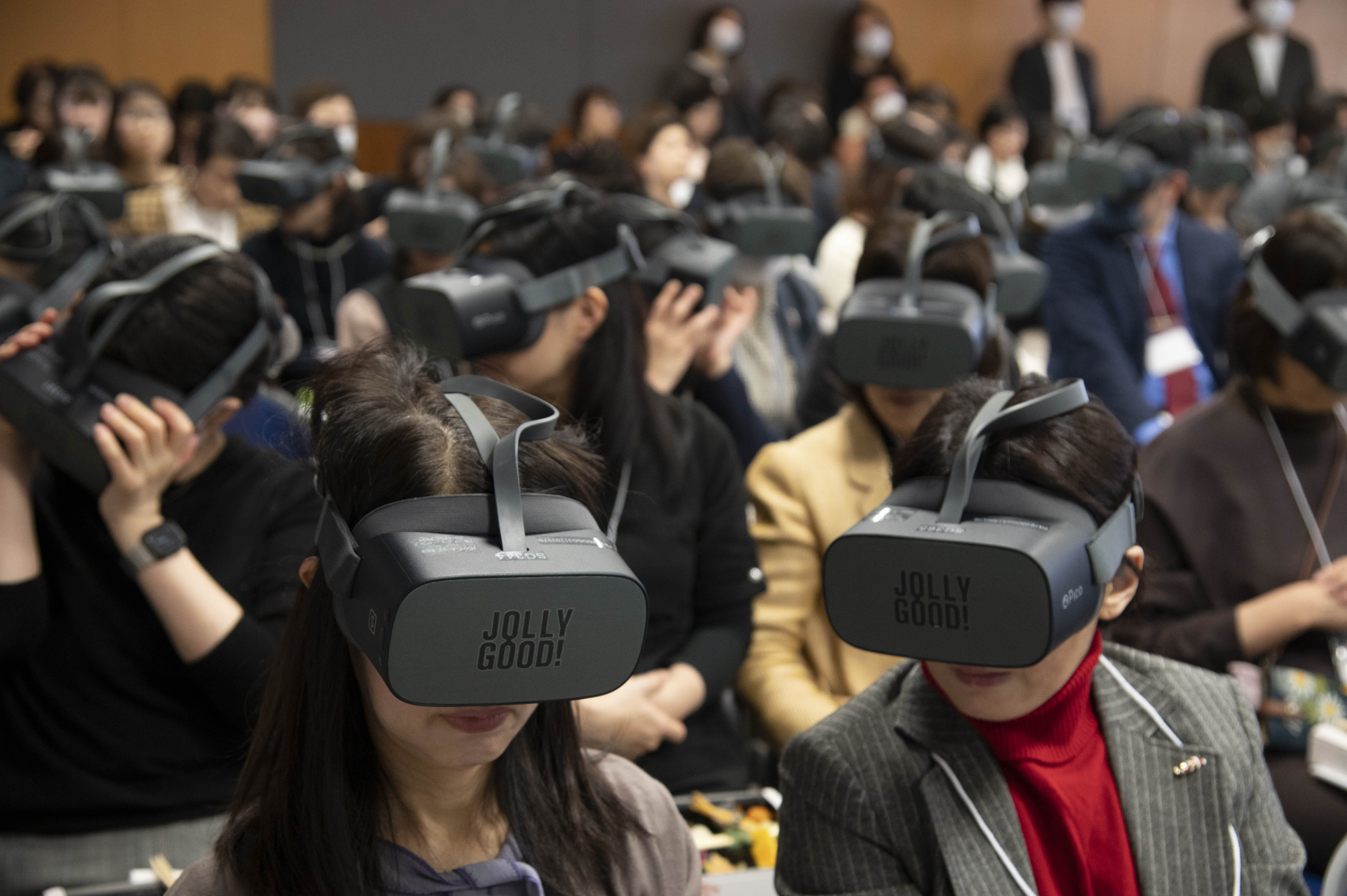 JOLLYGOODロゴが明瞭に見えるゴーグルを装着した看護学会の参加者